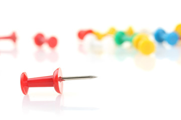 red pushpin against other