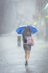 Girl walking at summer rain in the city