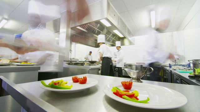 Time lapse of a busy team of chefs preparing food in a commercial kitchen