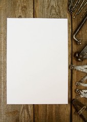 Paper with pencil and the vintage working tools on wooden
