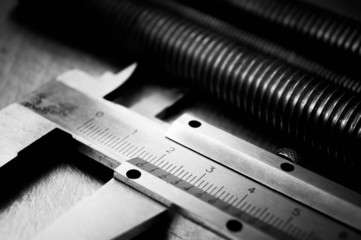 caliper and hairpins on scratched metal background.