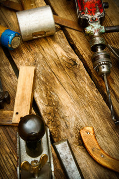 Vintage working tools (drill, saw, ruler and others) on wooden