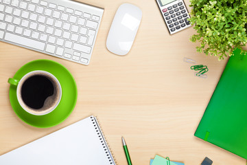 Office table with coffee cup, computer and flower