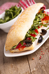 Sandwich with olives, bell pepper and arugula