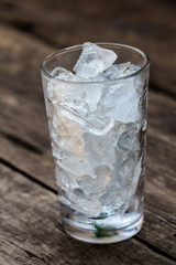 A glass of ice cubes on wooden