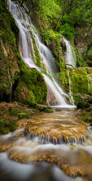 Fototapeta Piękny wodospad wśród klifów w okresie wiosennym