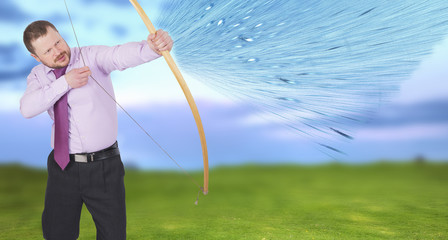 Businessman practicing archery with green field in background