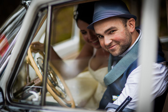 groom and bride in car