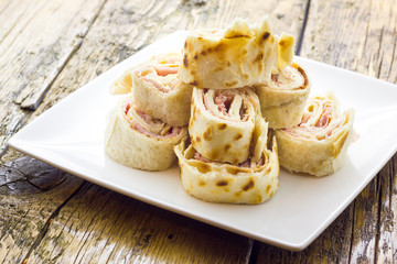 Roll of piadina with ham and cheese