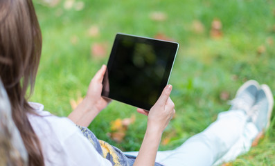 Young Woman using digital Tablet in Park