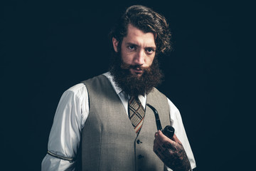 Stylish man with a beard smoking a pipe