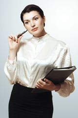 Naklejka premium Young girl in a white blouse with a folder and pen in hand