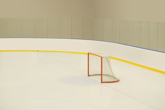 Empty hockey goal on ice rink.