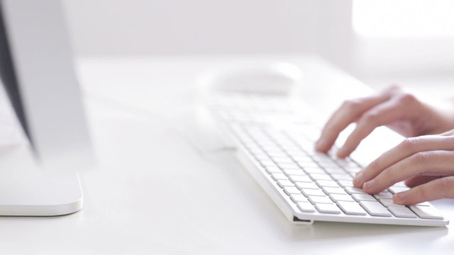 close up of hands typing on computer keyboard