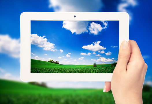 tablet computer in hand on the field backgrounds