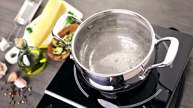 Cooking organic pasta with garlic herbs and parmesan cheese.
