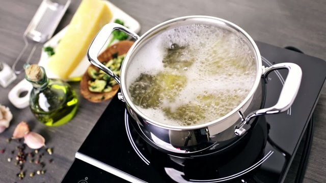 Cooking organic pasta with garlic herbs and parmesan cheese.