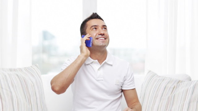 happy man calling on smartphone at home