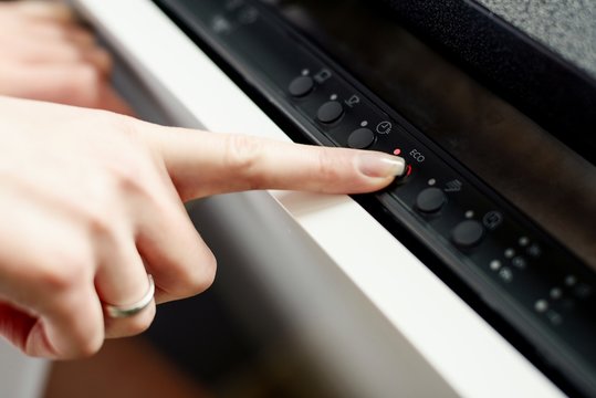 Woman Using Dishwasher In Energy Saver Mode.