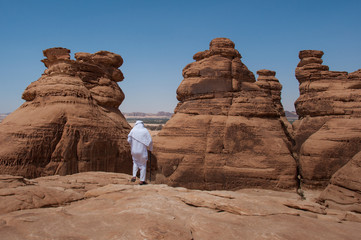 Fototapeta na wymiar Saudian walking on top of rock formations, Saudi Arabia