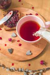 tea with pouring milk, homemade bread with blackcurrant jam