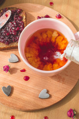 tea with pouring milk, homemade bread with blackcurrant jam