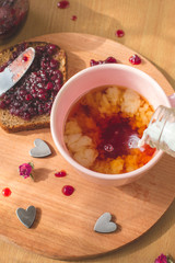 tea with pouring milk, homemade bread with blackcurrant jam