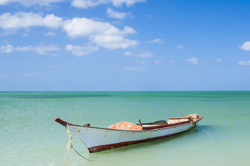 Vieja barca de madera vacía en el idílico paisaje de una playa caribeña en el Cabo de la Vela en la región de la Guajira en Colombia