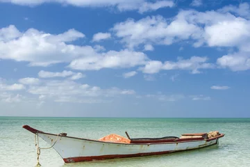 Poster Vieja barca de madera vacía en el idílico paisaje de una playa caribeña en el Cabo de la Vela en la región de la Guajira en Colombia © anamejia18