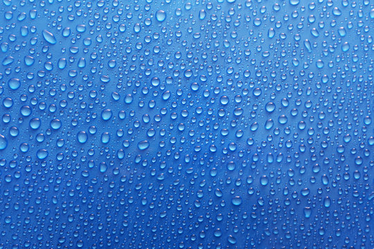 Water drops on glass on blue background