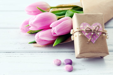 Beautiful pink tulips in paper with present box