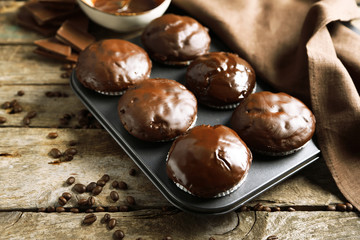 Tasty homemade chocolate muffins on wooden table