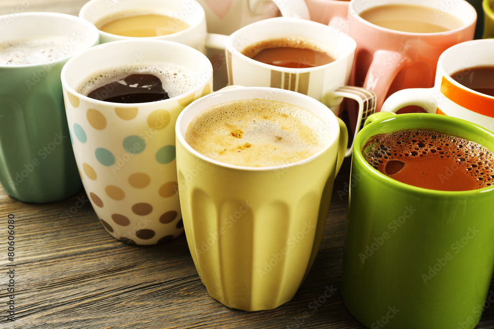 Poster Many cups of coffee on wooden table, closeup