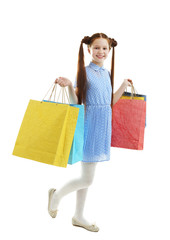 Beautiful little girl with shopping bags, isolated on white