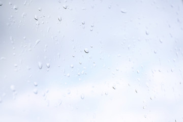 Raindrops on glass window overlooking the street on background