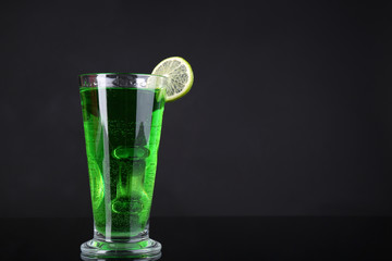 Flaming green cocktail on dark background