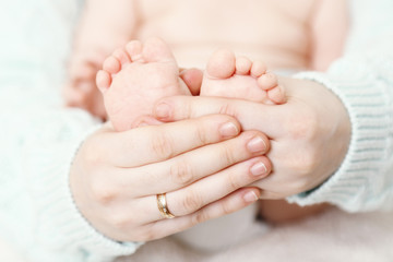 Newborn baby in mother hugs, close-up