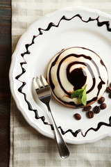 Tasty panna cotta dessert on plate, close up