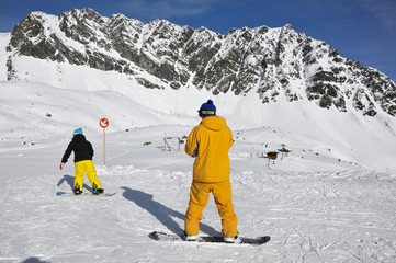 zwei Snowboarder auf der Piste