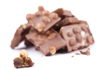 Milk chocolate with hazelnuts on white background