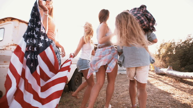 American teens walking with flag into sun flare
