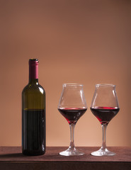 Red wine bottle and two filled wineglasses