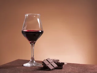 Gordijnen Red wine glass and chocolate © patronestaff