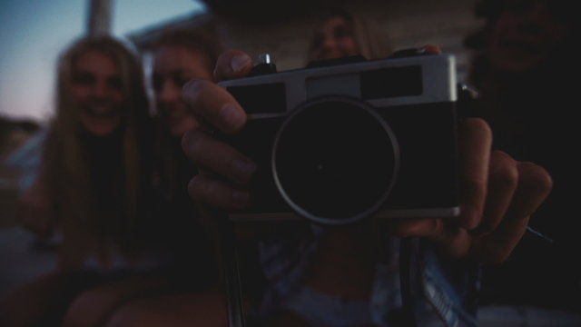 Teen friends posing in a row with a vintage camera