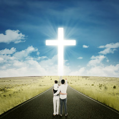 Happy family on the road with a cross