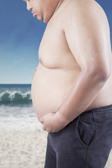 Sad man looking at his fat tummy