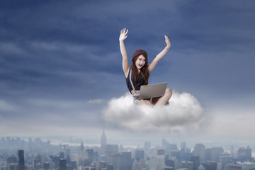 Fototapeta na wymiar Successful brunette girl with laptop on cloud