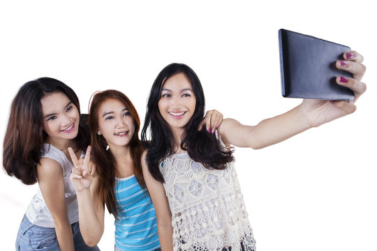 Three cheerful girls taking selfie