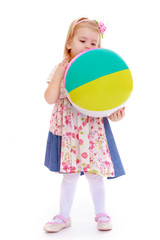 Little girl in a summer dress with ball