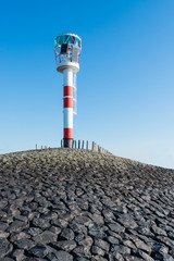 Red and white beacon at the end of a jetty